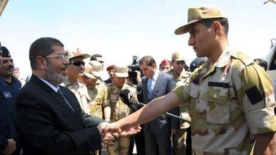 Egyptian president Mohammed Morsi (left) greets one of the Egyptian officers who was released by kidnappers in the Sinai Peninsula.