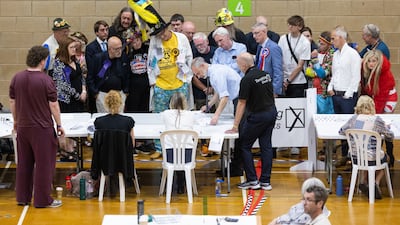 Election candidates and supporters observe spoilt ballot papers being verified. The by-election was won by Reform UK leader Nigel Farage. Bloomberg