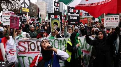 Anti-war activists hold signs and images of Iran's late supreme leader Ayatollah Ali Khamenei at a protest outside the US embassy in London. Reuters