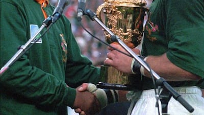 South Africa captain Francois Pienaar accepts the Webb Ellis trophy from Nelson Mandela after the team's win in the 1995 Rugby World Cup final win over New Zealand. Ross Setford / AP / June 1995