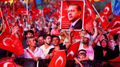 Supporters of Turkish president Recep Tayyip Erdogan wave national flags as they listen to him through a giant screen in Istanbul's Taksim Square. Osman Orsal / Reuters