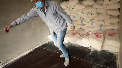 A worker wearing a protective mask unloads a sack of flour in Sidon, Lebanon. Reuters
