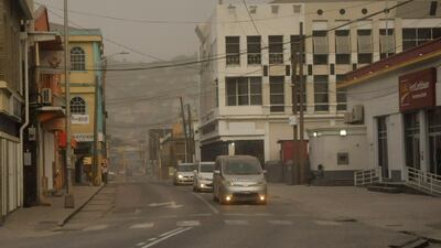 Cars drive along roads covered in ash in Kingstown. About 16,000 people have fled the eruption. Reuters
