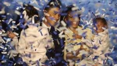 Obama, his wife Michelle, and daughters, Malia and Sasha, are showered with ticker tape after his acceptance speech, delivered in Chicago in November last year. M