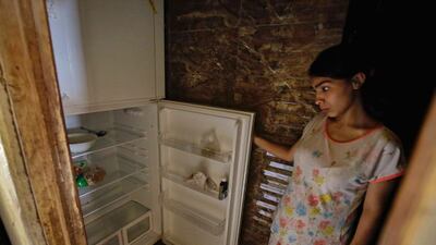 A Lebanese woman stands next to her empty refrigerator in her apartment in the port city of Tripoli. AFP