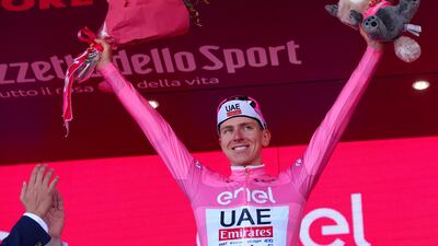 UAE Team Emirates rider Tadej Pogacar celebrates on the podium in his pink jersey after maintaining the overall race lead. AFP