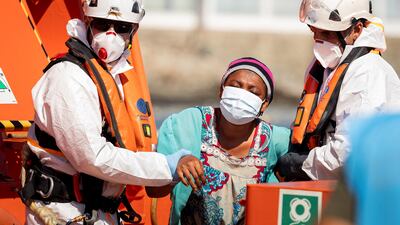 Sea Rescue workers help a migrant on her arrival at Arguineguin harbour, Gran Canaria, Canary Islands, Spain, on Tuesday. Photo: EPA