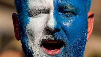The flag of Scotland is painted on his face. AP