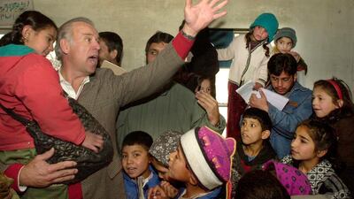 U.S. Sen. Joseph Biden, D-Del., Chairman of the U.S Senate's Foreign Relations Committee, waves as he talks to Afghan children during a visit to the Ariana primary school in Kabul, Jan. 12, 2002. AP Photo