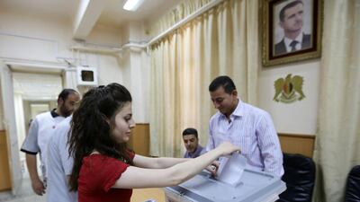 A Syrian woman casts her ballot as she votes in presidential election on June 3, 2014 at Bassel Al Assad school which was turned into a polling station in central Damascus. Louai Beshara/AFP Photo