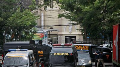 Police vehicles are parked near a Catholic cathedral where an explosion went off in Makassar. AP Photo