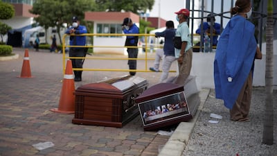 People wait next to coffins outside of Guasmo Sur General Hospital after Ecuador reported new cases of coronavirus disease (COVID-19), in Guayaquil, Ecuador. REUTERS