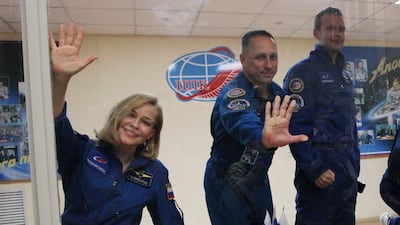 Cosmonaut Anton Shkaplerov (centre), actress Yulia Peresild and film director Klim Shipenko, gesture behind a glass wall during a news conference ahead of the expedition to the International Space Station (ISS). AFP
