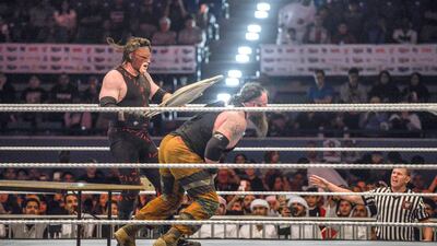 Kane hits Braun Strowman after being disqualified from their match on the opening night of WWE's visit to Abu Dhabi. Khushnum Bhandari / The National