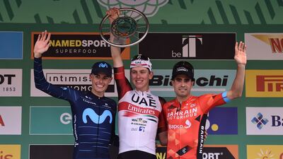 Tadej Pogacar celebrates on the podium after winning the Giro di Lombardia, next to runner-up Enric Mas, left, and third-placed Mikel Landa. EPA
