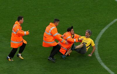 A man is tackled by security after invading the pitch during Sunday's game. Albert Gea / Reuters
