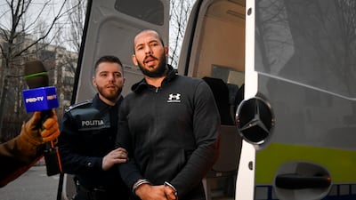 Police officers escort Andrew Tate to be questioned by criminal investigators in Bucharest on Wednesday. AP