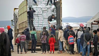 Displaced Syrians queue to receive humanitarian aid, consisting of heating material and drinking water, at a camp in the town of Mehmediye. AFP