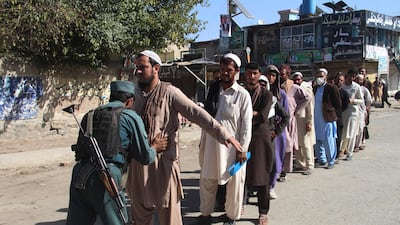 An Afghan policeman searches voters before casting their votes at a polling centre for the country's legislative election in Khost Province. AFP