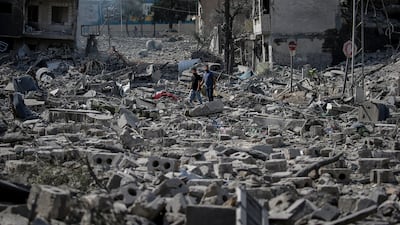 Palestinians walk among the rubble of destroyed buildings in Al Ramal neighbourhood after an Israeli air strike in Gaza city. EPA