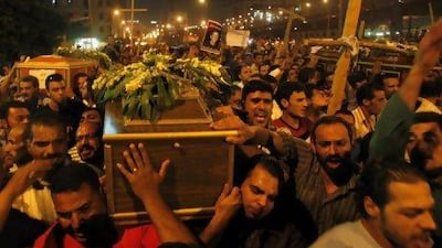 Coptic Christians carry coffins as they make their way to Abassaiya Cathedral during a mass funeral for victims of clashes with soldiers and riot police. Mohamed Abd El-Ghany / Reuters