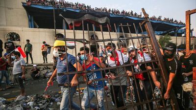 Protesters walk with a piece of metal fencing during clashes with security forces. AFP