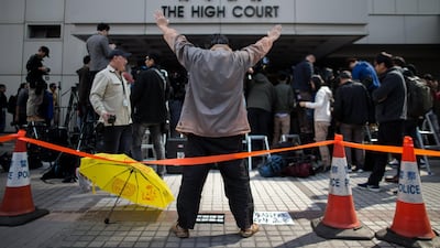 A pro-democracy supporter with a yellow umbrella shouts slogans outside the High Court in Hong Kong. Jerome Favre / EPA