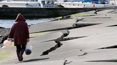 A woman walks on a destroyed dock at a fishing port in Yamada, Iwate Prefecture, northern Japan, last month. Japan will mark the second anniversary of the earthquake and tsunami that hit its north-east on Monday. EPA