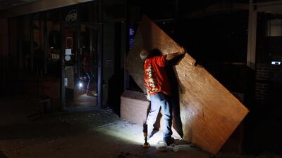 Workers board up the windows of a restaurant damaged by a tornado in Griffin. EPA