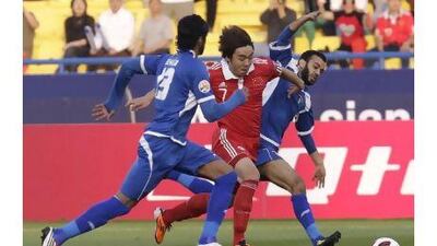 China's Zhao Xuri, in red, vies for the ball with two Kuwaiti players. China kicked off their Asian Cup campaign with a 2-0 win over Kuwait yesterday to boost their hopes of reaching the knockout stages. Hussein Malla / AP Photo