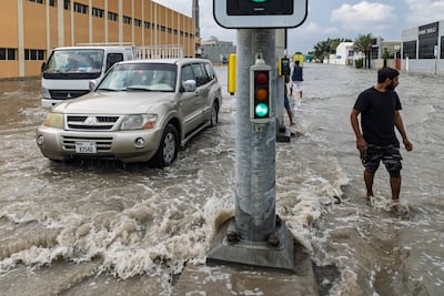 Drivers and pedestrians work their way through flooded streets in the Al Quoz area of Dubai following last week's downpours. Antonie Robertson / The National