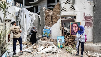 Palestinian artists display artwork in the courtyard of the damaged Arts and Crafts Village, which was hit by Israeli air strikes on July 14, 2018. AFP