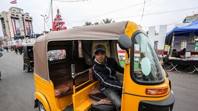 A youth drives a tuktuk at the anti-government protest sit-in in the Iraqi capital Baghdad's central Tahrir Square. AFP