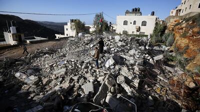 The parents of 19-year-old Muhanad Halabi stand amid the debris of their home in the West Bank village of Surda on January 9, 2016, after Israeli army bulldozers demolished it overnight. Abbas Momani/AFP Photo