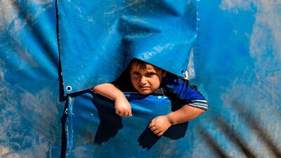 A boy peeks out from a hole in the side of a tent at the Washukanni camp for the internally displaced near the town of Tuwaynah, west of Syria's northeastern city of Hasakah. AFP