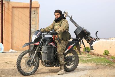 An anti-government fighter rides his motorcycle in the city of Al Rastan in Syria's west-central province of Homs on Saturday. AFP