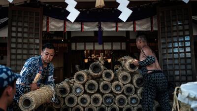 Men piling handmade Tezutsu hanabi which will be purified before being dedicated to the Yoshida Shrine. AFP