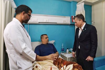 UN humanitarian chief Tom Fletcher, right, visits an injured Palestinian at a hospital in Egypt. EPA