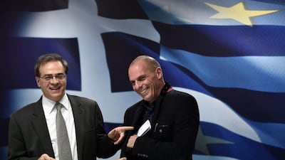 Greece's outgoing finance minister, Gikas Hardouvelis, jokes with new finance minister Yanis Varoufakis after a ministry hand-over ceremony in Athens on January 28, 2015. Aris Messinis/AFP Photo