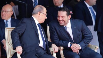 Saad Hariri talks with Lebanese President Michel Aoun while attending a military parade in Beirut. Reuters, File