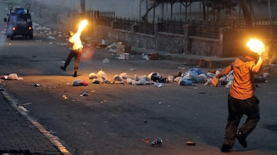 Masked men throw petrol bombs at Istanbul police who used water cannons and teargas to disperse people protesting against security operations in southeastern Turkey. Omer Kuscu / AP Photo