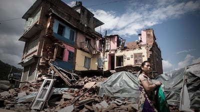 An earthquake survivor walks past a destroyed house in Chautara, about 80km from Kathmandu. Philippe Lopez / AFP