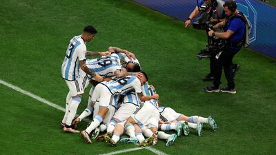 Lionel Messi is mobbed by Argentina teammates after scoring. Getty