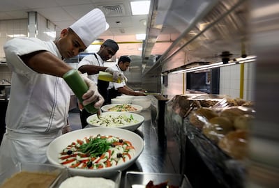 Staff prepare dishes at Armani Hotel, which also donates to the food bank, on Wednesday. Satish Kumar for The National