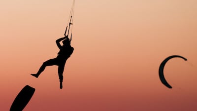 A kitesurfer soars into the air above the sea as the sun sets in Marseille, south-eastern France. AFP