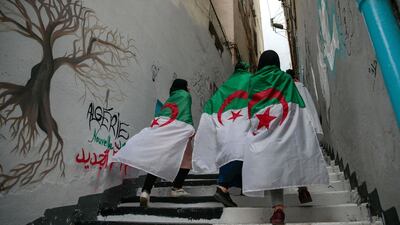Female protesters wrapped in Algerian flags walk past during a demonstration in Algiers, Algeria, Wednesday, April 10, 2019. AP