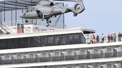 People on a deck of the Westerdam cruise ship watch a helicopter take off in Sihanoukville as authorities checked if any passengers that remained could have the COVID-19 coronavirus. AFP