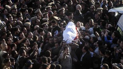 Egyptians carry the body of a policeman who was killed along with 15 other people in a suicide bombing of the police headquarters in Mansoura. Mahmoud Khaled / AFP
