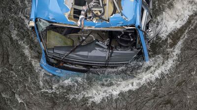 The wreck of the partially submerged bus lies in the Lerez river. AFP