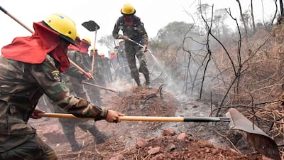 Bolivian soldiers combat forest fires in Otuquis National Park, in the Pantanal ecoregion of southeastern Bolivia, on August 26, 2019. Like his far right rival President Jair Bolsonaro in neigboring Brazil, Bolivia's leftist leader Evo Morales is facing mounting fury from environmental groups over voracious wildfires in his own country. While the Amazon blazes have attracted worldwide attention, the blazes in Bolivia have raged largely unchecked over the past month, devastating more than 9,500 square kilometers (3,600 square miles) of forest and grassland. / AFP / Aizar RALDES